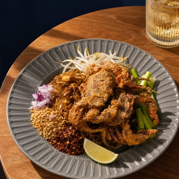 Pad Thai with crispy soft-shell crab, bean sprouts, peanuts, red onion, chili flakes, and lime.